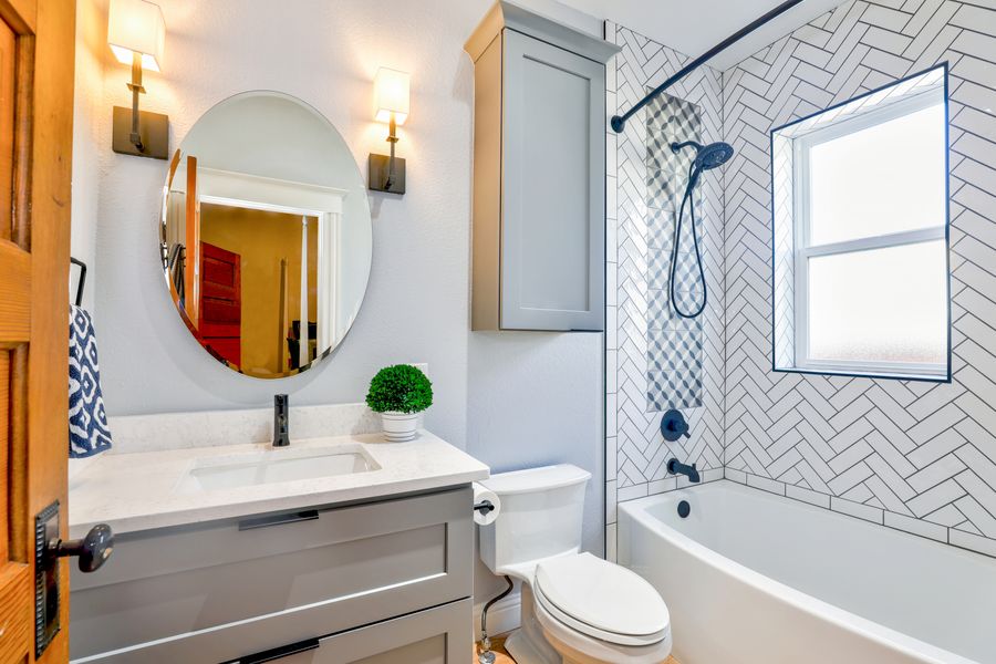 Bathroom with herringbone tiled shower over bath